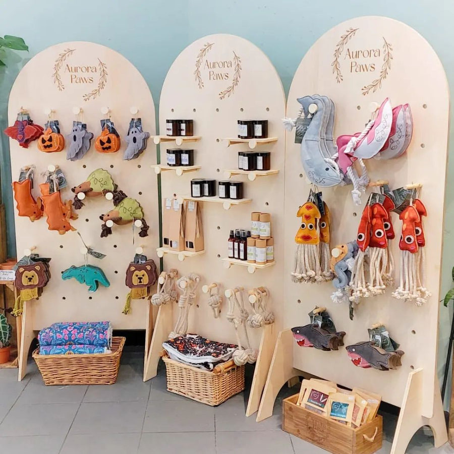 Curved pegboard stands full of handmade products at a market stall